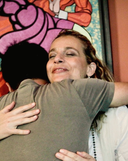 Marcela Benson embracing a student